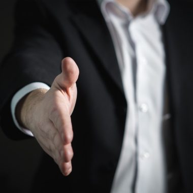 Un empresario extendiendo una mano para realizar un acuerdo de negocios